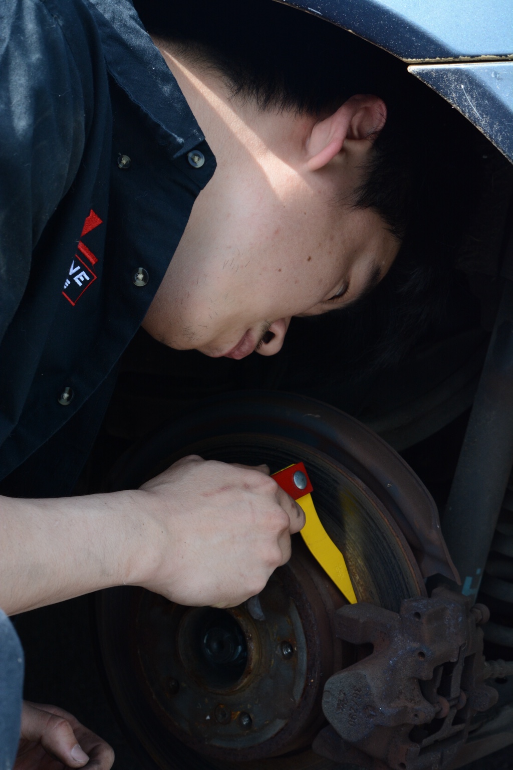 Ryan checking a brake rotor with a measuring tool