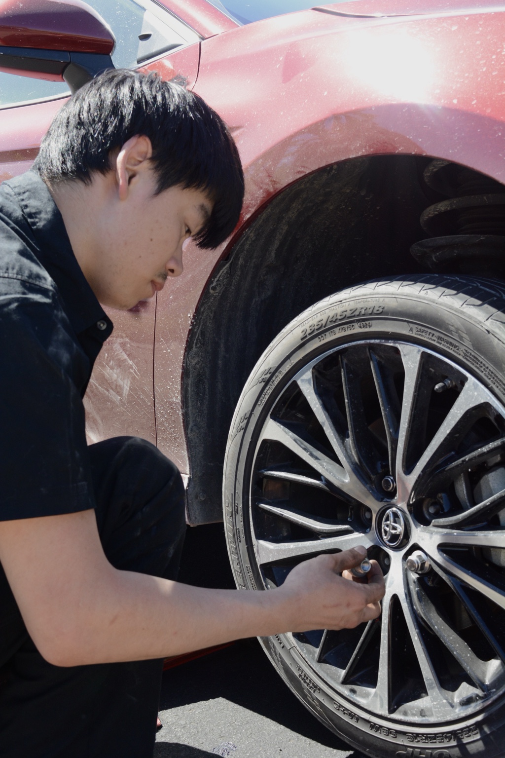 Ryan installing a wheel on a red Toyota
